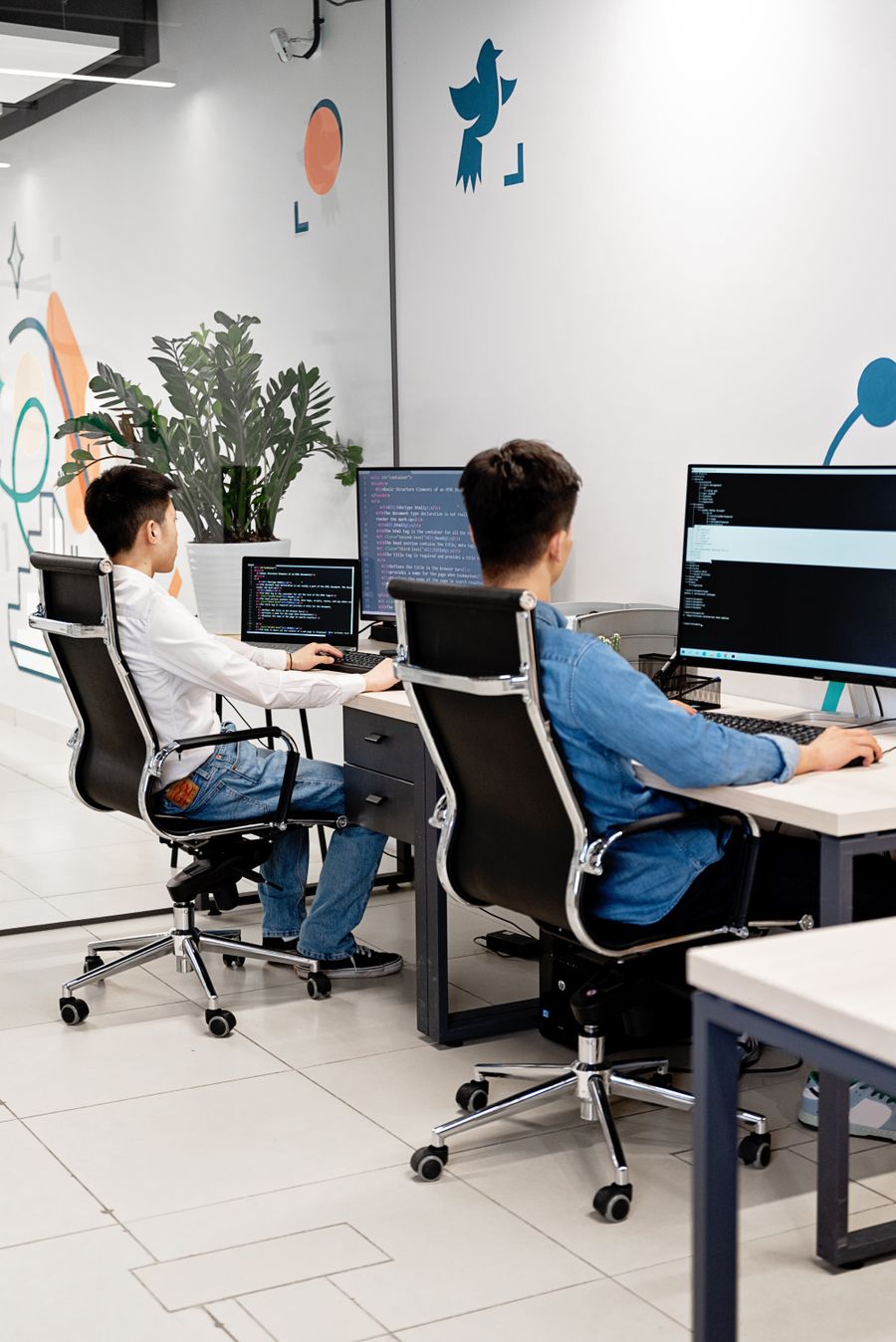 Developers collaborating on a website build across dual monitors